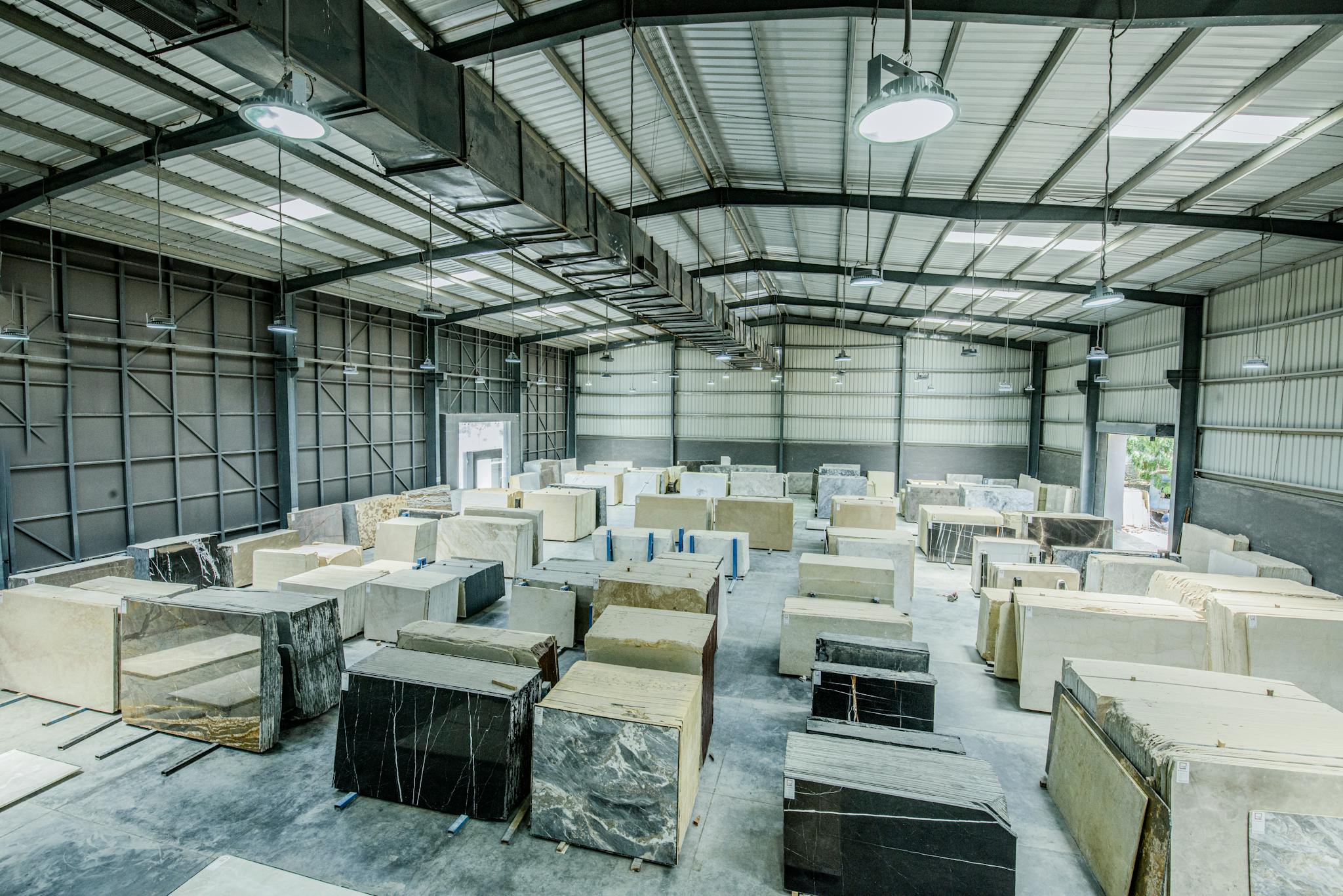Expansive warehouse filled with large stone slabs for industrial use.